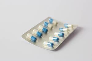 Weiß-blaue überzogene Tabletten vor weißem Hintergrund