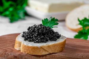 Weißbrot mit Butter und schwarzem Kaviar, als Gourmetsnack, in der Nahaufnahme