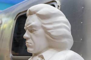 Weiße Beethoven-Statue passend zum Beethoven-Jahr 2020, vor einem alten Campingvan