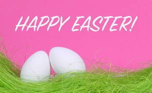 Weiße Ostereier auf grünem Gras vor Text Happy Easter auf rosa Hintergrund
