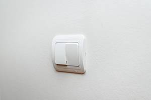 Weißer Doppel-Lichtschalter an einer weißen Wand