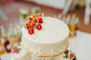 Weißer Kuchen mit Streuseln, Beeren und Früchten verziert