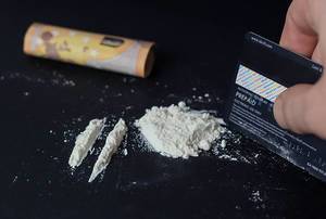 Weißes Pulver zum Drogenkonsum vorbereitet, mit gerolltem Geldschein zum sniefen