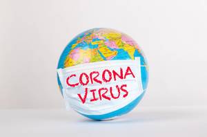Weltkugel mit Gesichtsmaske mit den Worten Coronavirus auf weißem Hintergrund