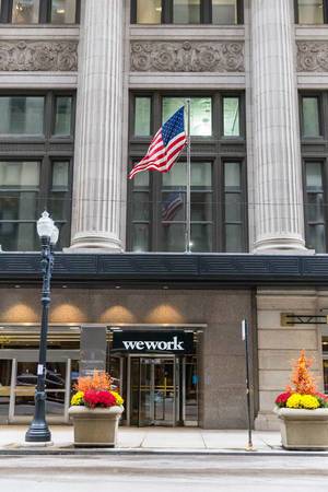 WeWork Schild und USA-Fahne am Eingang des Bürokomplexes "The National" in sehr zentraler Lage in Chicago