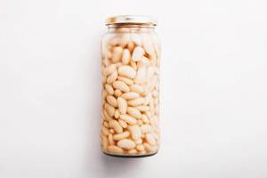 White beans in a jar on white background