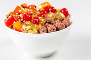 White bowl with corn balls and fruit on a white background (Flip 2020)