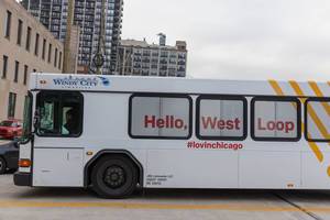 White bus with #lovingchicago and "Hello, West Loop" written on the side in Chicago