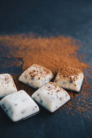 White chocolate pieces with cinnamon on dark background