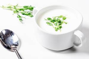 White mushroom soup with micro greenery and spoon on white background (Flip 2019)