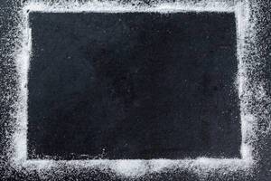 White sugar frame on black background