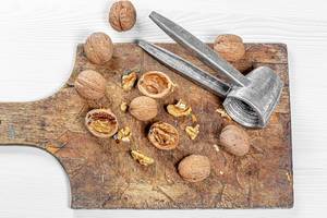 Whole and broken walnuts on an old wooden Board. Top view
