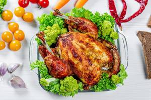 Whole baked chicken with vegetables and spices.Top view