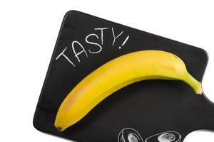 Whole Banana on the black tray with Tasty sign