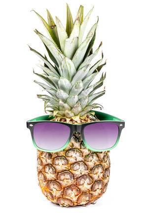 Whole raw fresh pineapple with sunglasses on white background. Summertime holiday concept