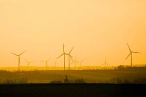 Windpark beim Sonnenuntergang: Windkrafträder in Dorfnähe