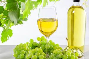 Wine background with ripe fresh grapes, full bottle and glass and green branches with leaves (Flip 2019)