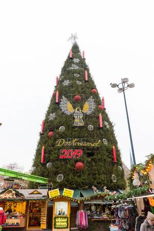 Winter market in Dortmund, Germany: decorated green Christmas tree with festive ornaments and angles