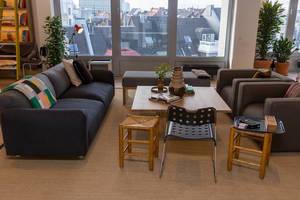 Wohnzimmerecke im Gemeinschaftsbüro des Coworking-Space WeWork, mit Blick auf Köln