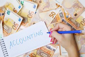 Woman hand writing Accounting, 50 Euro banknotes background