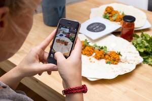 Woman takes a food picture with her smartphone