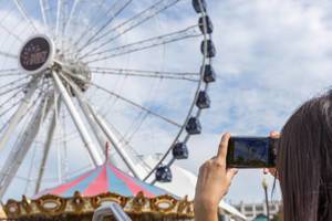 Woman takes a picture of a Ferris wheel at Navy Pier in Chicago