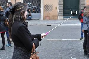 Woman takes a selfie with a stick