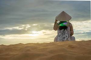 Woman watching the Sunset in the Red Sand Dunes of Mui Ne, Vietnam