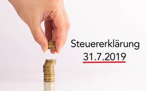 Womans hand picking up coins with Steuererklärung date