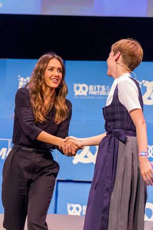 Women Entrepreneur Jessica Alba schüttelt die Hand einer Dame und lächelt dabei