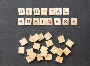 Wooden cubes on a stone surface show "Digital Business"
