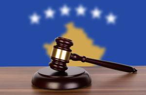 Wooden gavel and flag of Kosovo