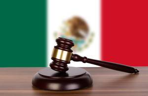 Wooden gavel and flag of Mexico