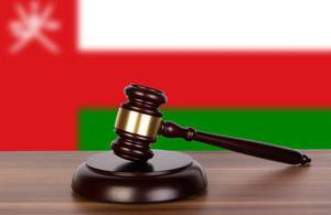 Wooden gavel and flag of Oman
