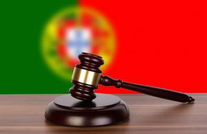 Wooden gavel and flag of Portugal