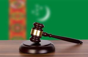 Wooden gavel and flag of Turkmenistan