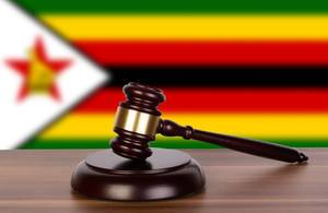 Wooden gavel and flag of Zimbabwe