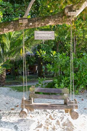 Wooden swing on a tree invites to sit and relax at Constance Ephelia Resort, to enjoy #myconstancemoment on Mahé, Seychelles