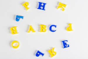 Yellow and blue plastic letters on a white background, top view