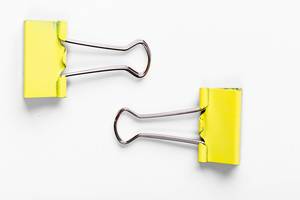 Yellow paper clip on white background
