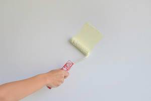 Yellow wall painting with paint roller