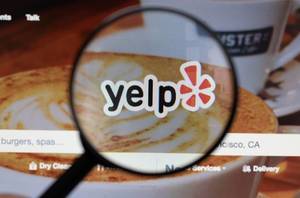 Yelp logo on a computer screen with a magnifying glass