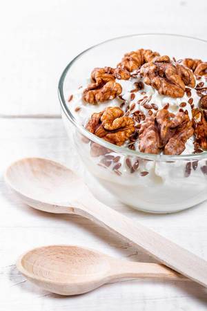Yogurt-curd dessert with walnuts close-up
