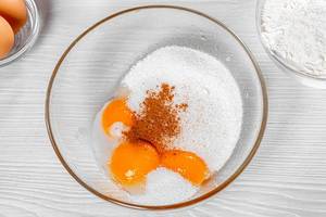 Yolks, sugar, vanilla and cinnamon in a bowl. View from above (Flip 2019)