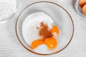 Yolks, sugar, vanilla and cinnamon in a bowl. View from above