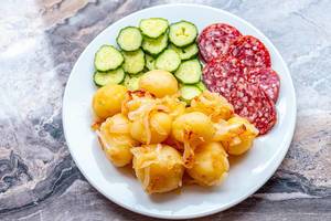 Young boiled potatoes with smoked sausage slices and cucumbers on a plate (Flip 2019) (Flip 2019)