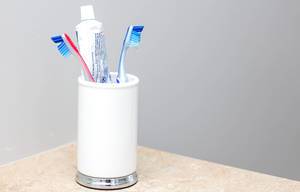 Zahnbürsten in weißer Tasse