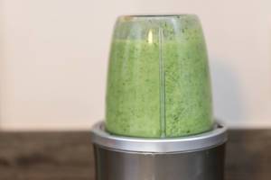 Zubereitung eines grünen Proteindrinks im Mixer, für eine sportliche, gesunde Ernährung