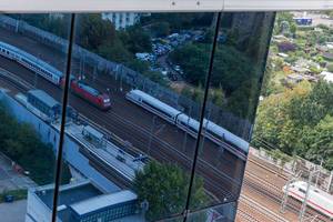 Zugverkehr an der Haltestelle S-Stresow spiegelt sich in der Glasfassade des Select Hotel Spiegelturms Berlin