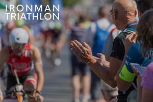 Zuschauer feuern Radrennfahrer beim sportlichen Event an, neben dem Bildtitel "Ironman Triathlon"